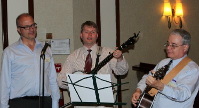 photo: Greg Mobley, Joe Cleveland, Chris Lanzara singing and playing banjo and guitar
